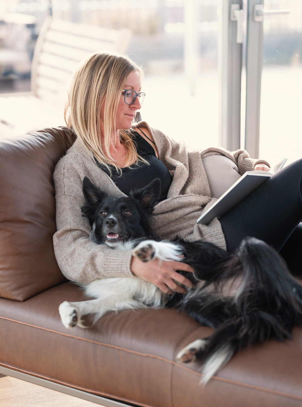 Entspannung auf dem Sofa mit Buch und Hund