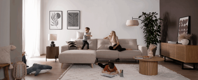 beiges Sofa auf dem Mutter und 2 Kindern spielen