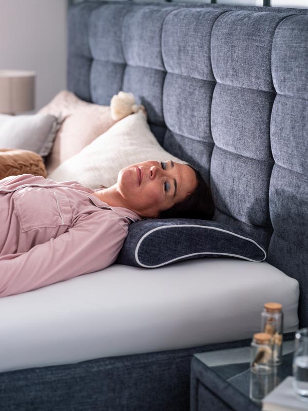 Frau macht ein Nickerchen im Bett und Kopf liegt auf einem Kissen