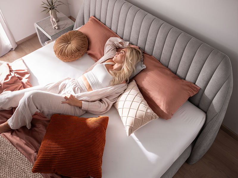 3xl-Suavis_Model_800x600px hellgraues Boxspringbett Suavis von ADA Möbel mit ruhender Dame