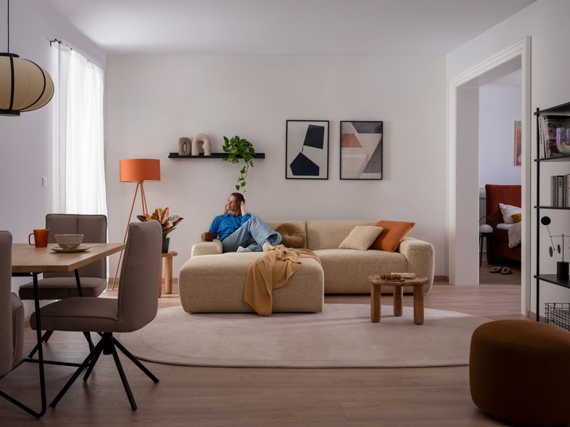beiges ADA Sofa PINEA mit Model in einer kleinen Wohnung