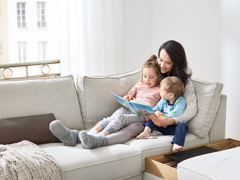 beiges ADA Sofa Novara mit sitzender Familie mit Kindern